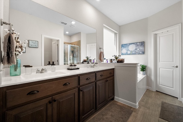 bathroom featuring double sink vanity, independent shower and bath, and hardwood / wood-style floors