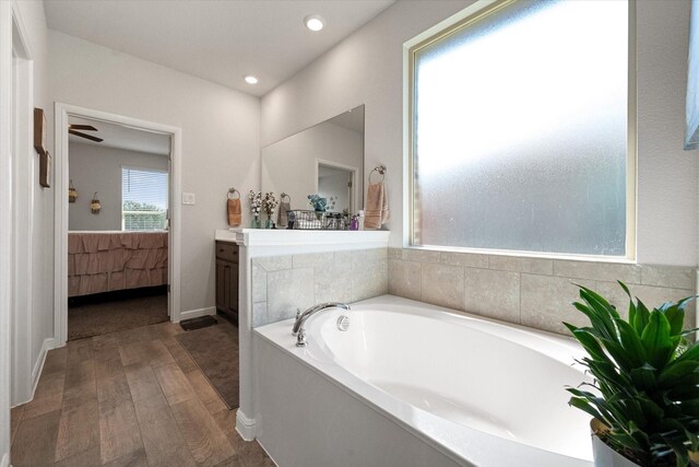 bathroom featuring ceiling fan, vanity, a bathing tub, and hardwood / wood-style flooring