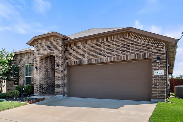 view of front facade with a garage and cooling unit