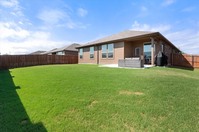 back of house with a patio area and a lawn