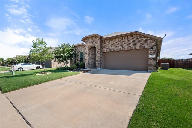 view of front facade with a garage, a front yard, and central AC unit