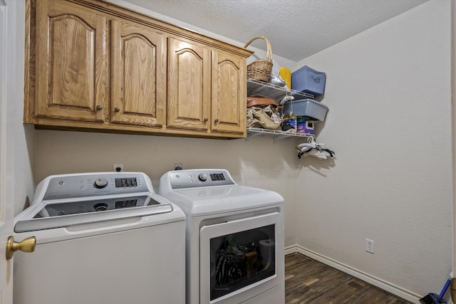 laundry room featuring cabinets, a textured ceiling, dark hardwood / wood-style floors, and separate washer and dryer