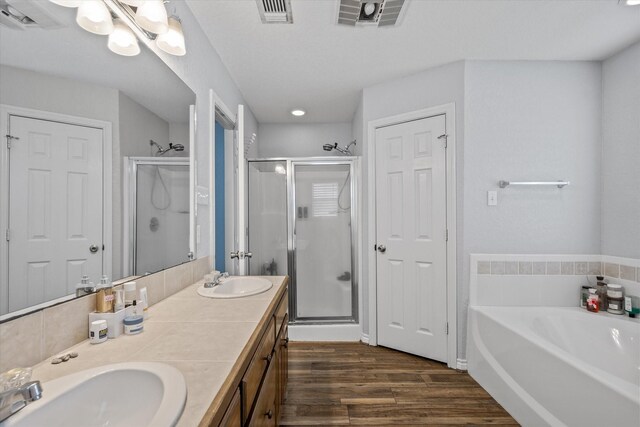 bathroom featuring double vanity, shower with separate bathtub, and hardwood / wood-style floors