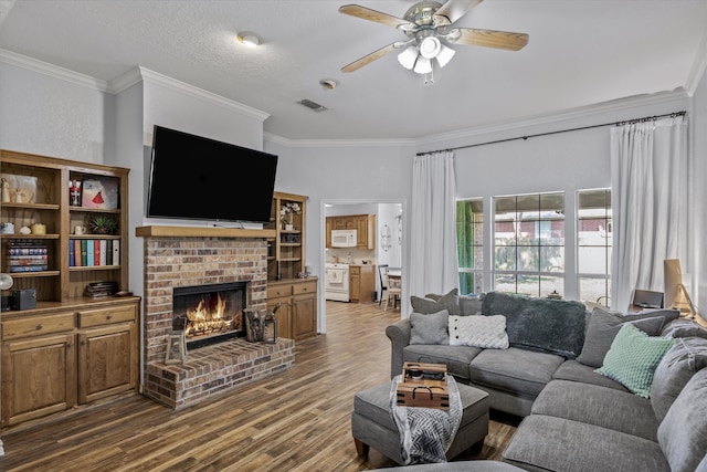 living room with a fireplace, ornamental molding, dark hardwood / wood-style floors, and ceiling fan