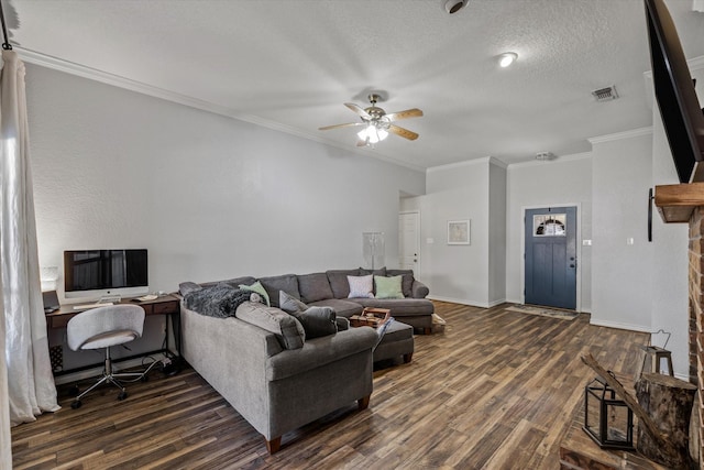 living area featuring a textured ceiling, ceiling fan, visible vents, ornamental molding, and dark wood finished floors