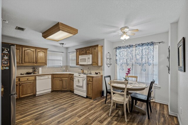 kitchen featuring white appliances, dark hardwood / wood-style floors, plenty of natural light, and sink