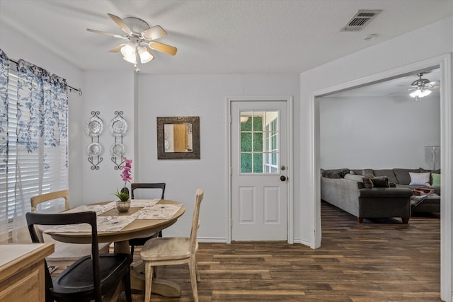 dining area with ceiling fan, dark hardwood / wood-style flooring, and a textured ceiling