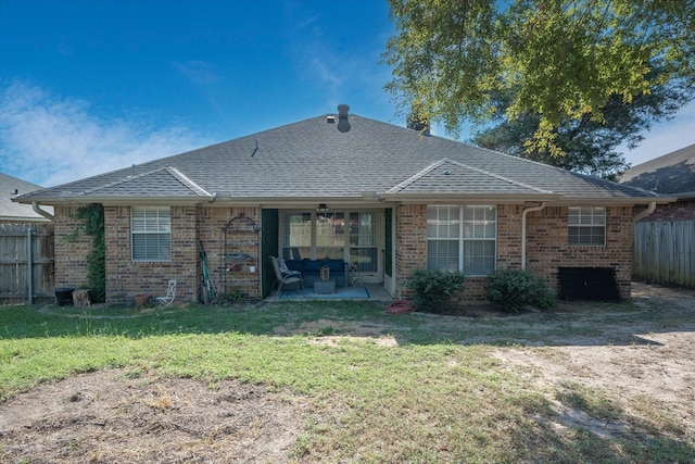 back of house featuring a yard, brick siding, a shingled roof, and fence