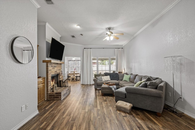 living area featuring crown molding, dark wood finished floors, a fireplace, and a textured wall