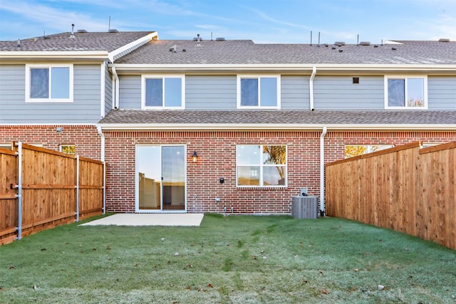 back of property with a patio, central AC, and a lawn