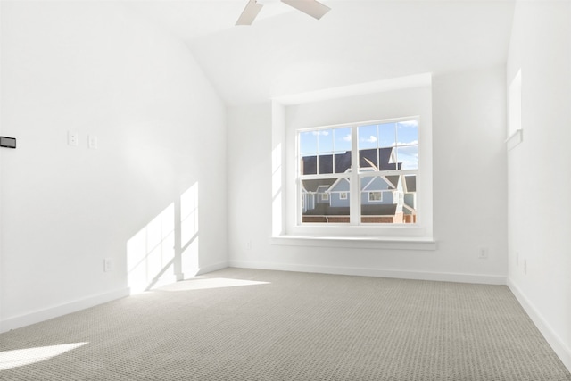 spare room with ceiling fan, vaulted ceiling, and carpet