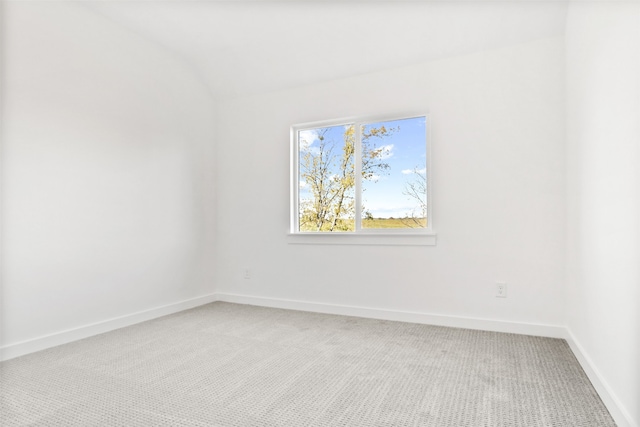 carpeted spare room with lofted ceiling