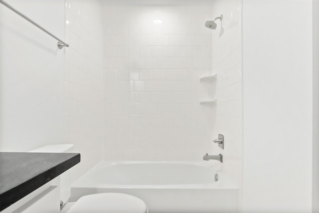 bathroom with toilet and tiled shower / bath combo