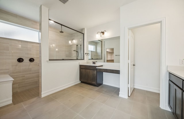 bathroom with vanity, plenty of natural light, and tiled shower