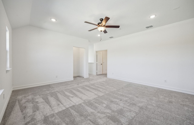 carpeted spare room featuring ceiling fan and vaulted ceiling