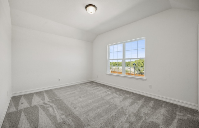 spare room featuring lofted ceiling and carpet floors