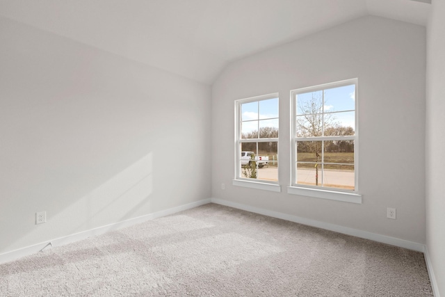 carpeted empty room featuring lofted ceiling