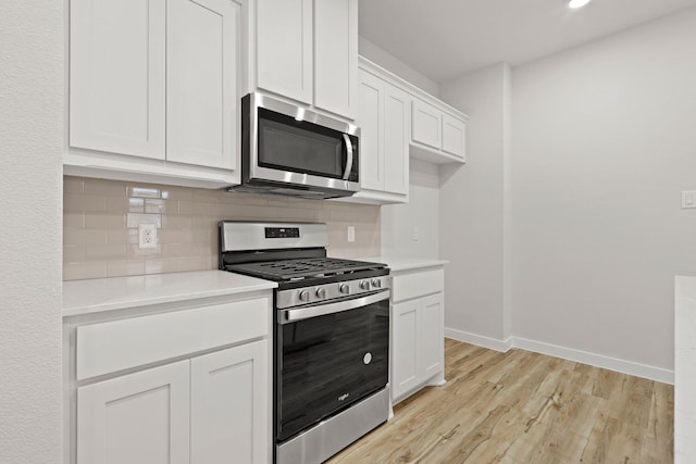 kitchen featuring stainless steel appliances, tasteful backsplash, white cabinets, and light hardwood / wood-style flooring