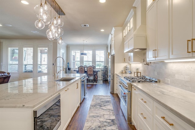 kitchen featuring glass insert cabinets, white cabinetry, a center island with sink, and appliances with stainless steel finishes