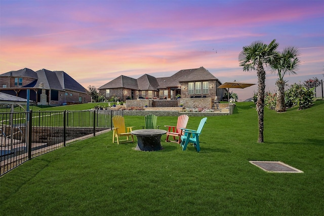 yard at dusk featuring fence and an outdoor fire pit