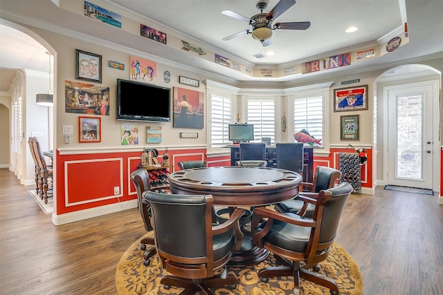 rec room with arched walkways, ornamental molding, and dark wood finished floors