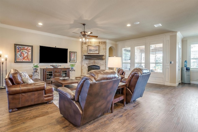 living room featuring wood finished floors, visible vents, and ornamental molding