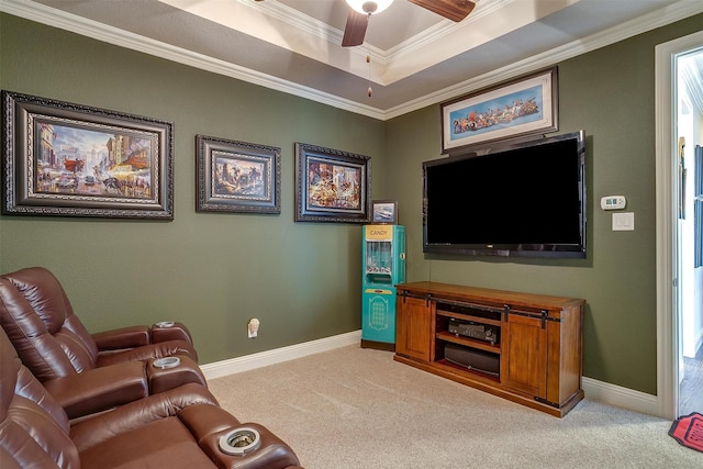 living room featuring ornamental molding, a tray ceiling, light colored carpet, and a ceiling fan