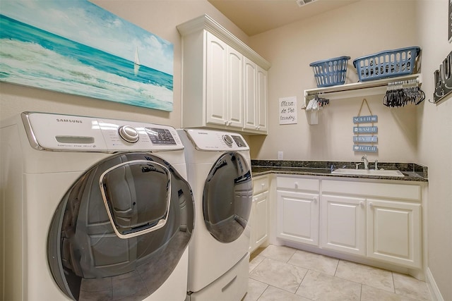 washroom with cabinet space, light tile patterned floors, visible vents, washer and dryer, and a sink