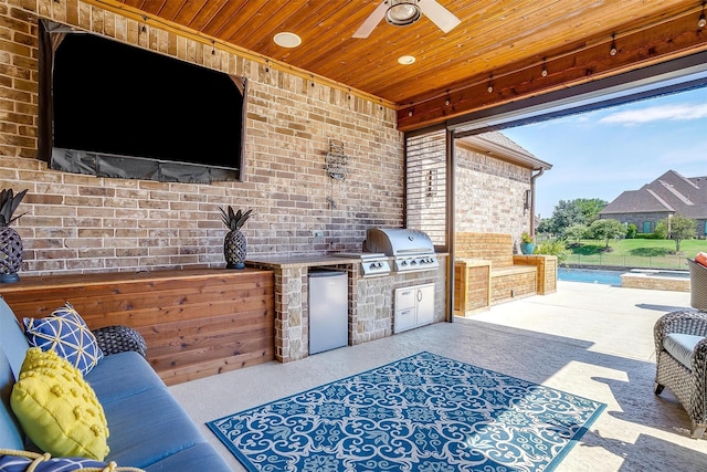 view of patio / terrace with ceiling fan, an outdoor kitchen, and a grill