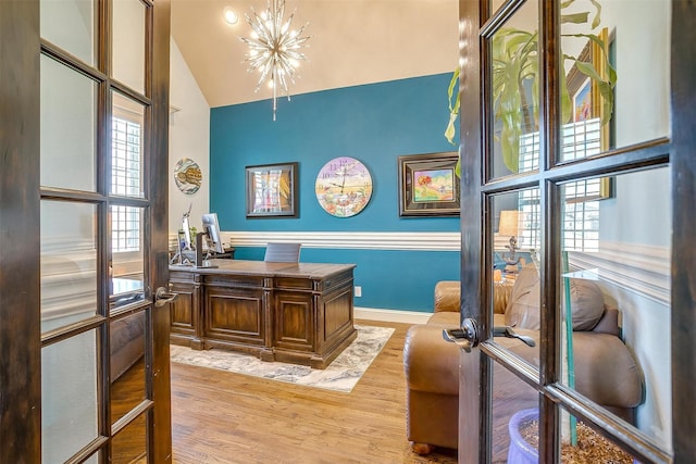 home office with french doors, light wood-style floors, a chandelier, and high vaulted ceiling