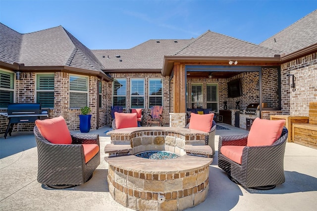 view of patio / terrace featuring exterior kitchen, an outdoor fire pit, and a grill