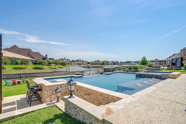 view of pool with an infinity pool, a lawn, fence, a residential view, and an outdoor bar