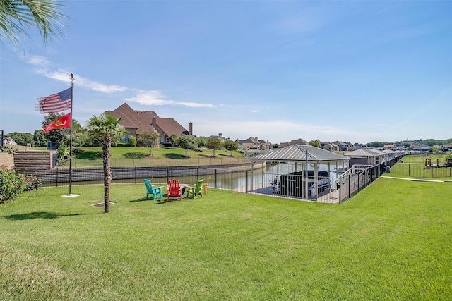 view of dock featuring a yard, a water view, a gazebo, fence, and a residential view