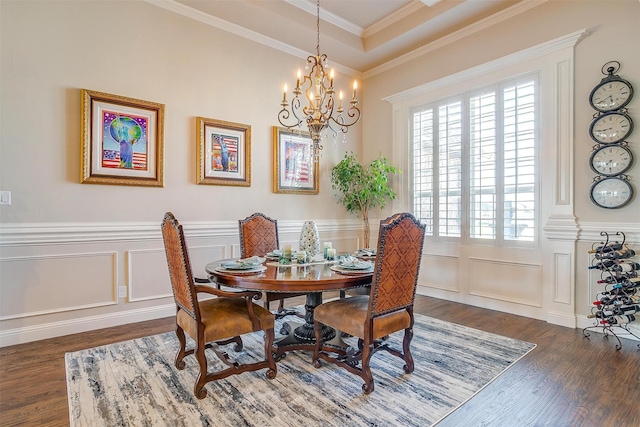 dining space with dark wood-style floors, ornamental molding, a notable chandelier, and a decorative wall