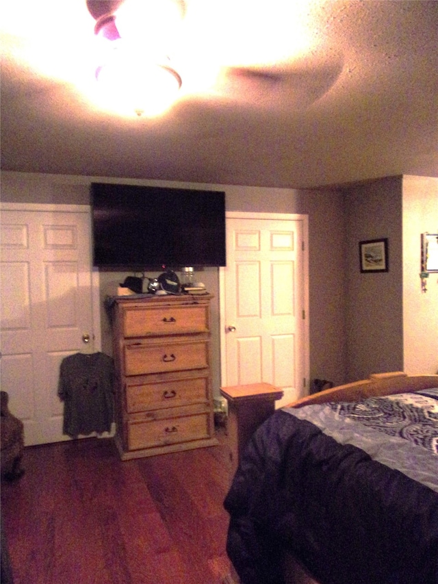 bedroom with ceiling fan and dark wood-type flooring