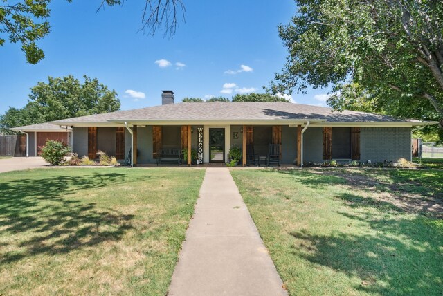 ranch-style house featuring covered porch and a front yard