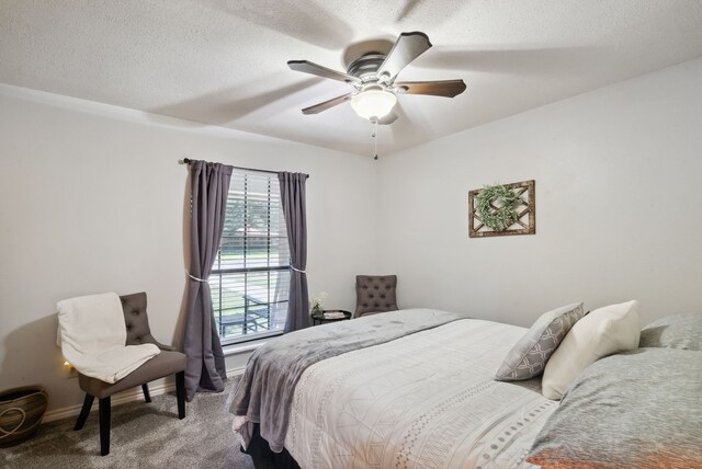 carpeted bedroom with ceiling fan and a textured ceiling