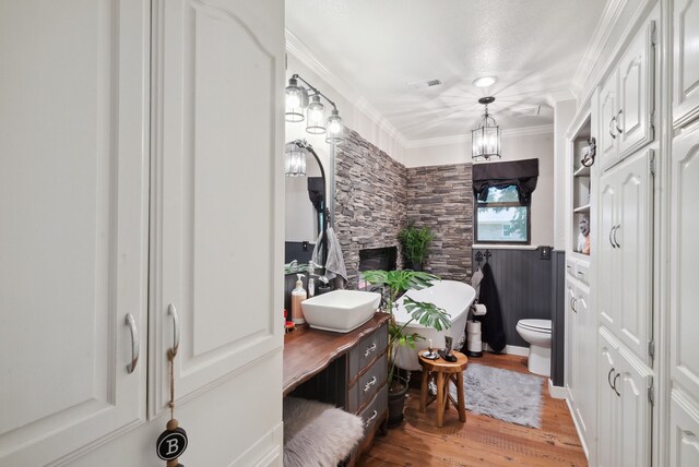 bathroom with toilet, crown molding, a notable chandelier, vanity, and hardwood / wood-style floors