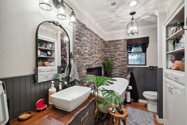 bathroom with hardwood / wood-style floors, a notable chandelier, toilet, vanity, and ornamental molding