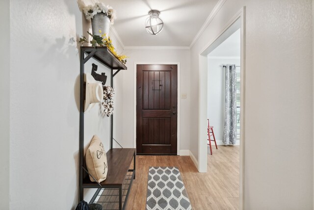 entryway featuring light wood-type flooring and ornamental molding