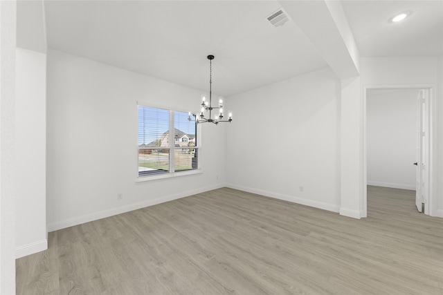 unfurnished dining area featuring light hardwood / wood-style flooring and an inviting chandelier