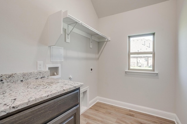 washroom with electric dryer hookup, hookup for a gas dryer, light hardwood / wood-style flooring, and washer hookup