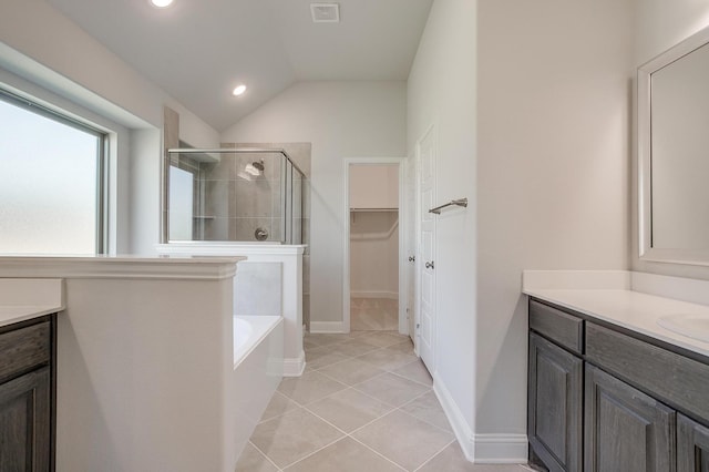 bathroom featuring lofted ceiling, vanity, plus walk in shower, and tile patterned flooring