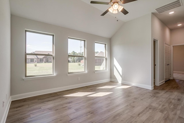 empty room with lofted ceiling, ceiling fan, and light wood-type flooring