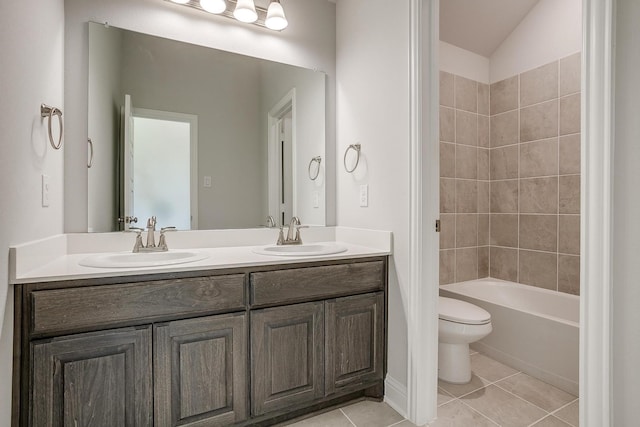 full bathroom with vanity, tiled shower / bath, vaulted ceiling, tile patterned flooring, and toilet