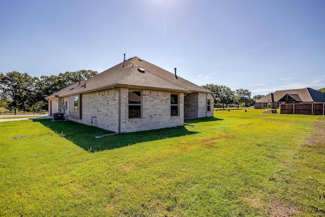 back of property with a yard and central AC unit