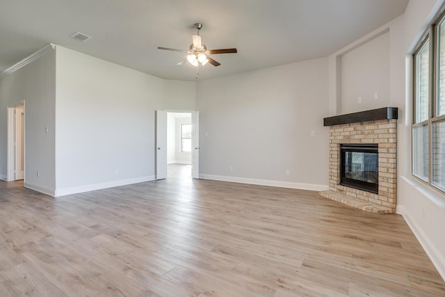 unfurnished living room featuring ceiling fan, light hardwood / wood-style floors, and a brick fireplace