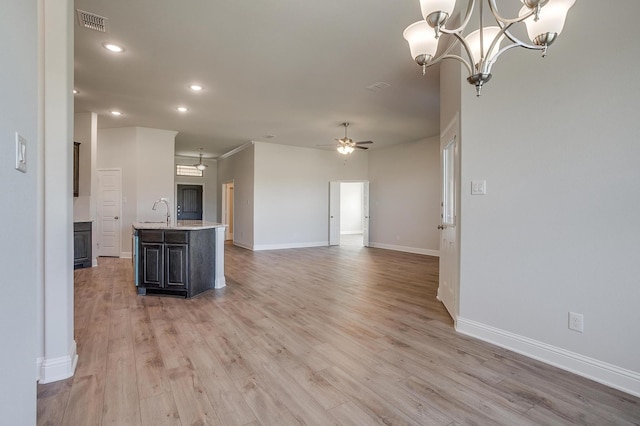 kitchen featuring sink, hanging light fixtures, light hardwood / wood-style flooring, a kitchen island with sink, and ceiling fan with notable chandelier