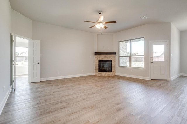 unfurnished living room with ceiling fan, light hardwood / wood-style floors, and a brick fireplace