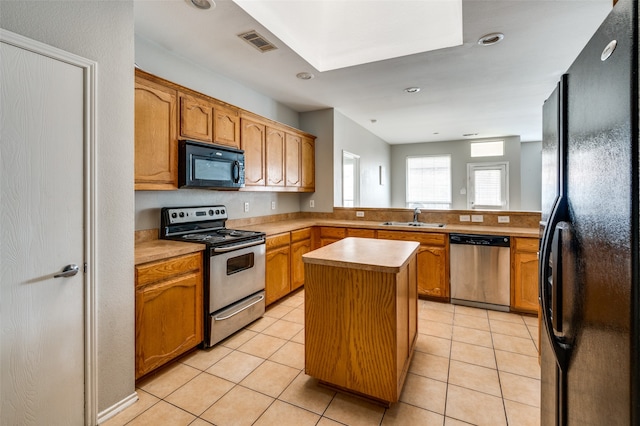 kitchen with light tile patterned floors, black appliances, a kitchen island, kitchen peninsula, and sink